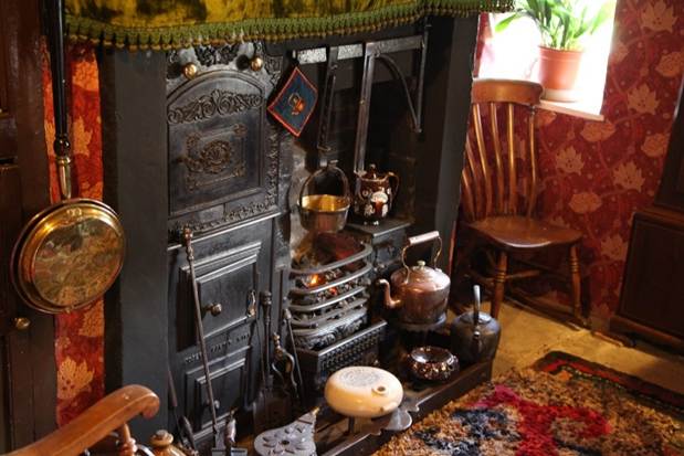 A kitchen with a fireplace and a chair
Description automatically generated with medium confidence